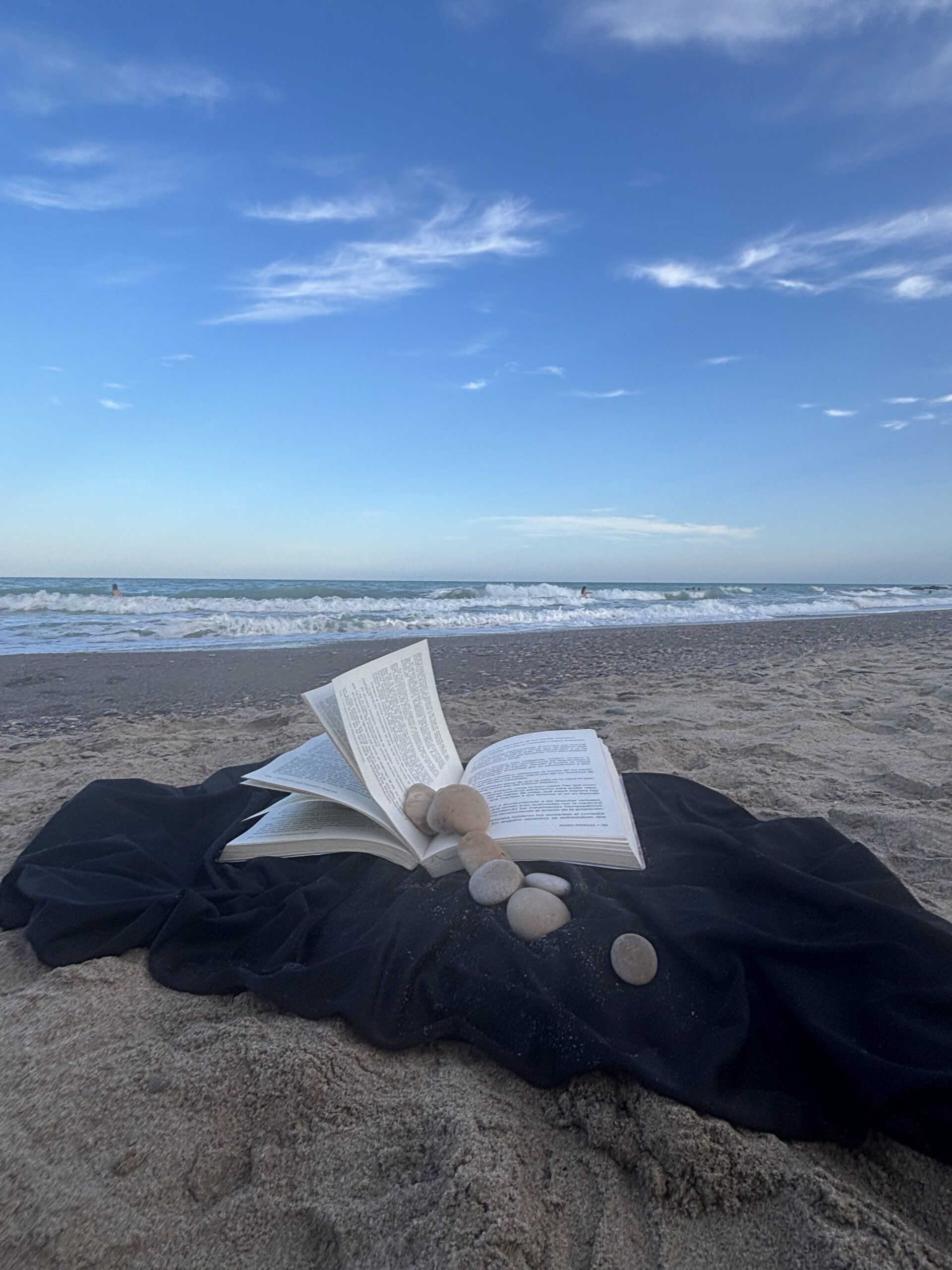 Libro abierto con fondo de mar y arena